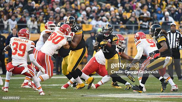 Running back Le'Veon Bell of the Pittsburgh Steelers runs with the football as offensive lineman Ramon Foster blocks linebacker Josh Mauga of the...