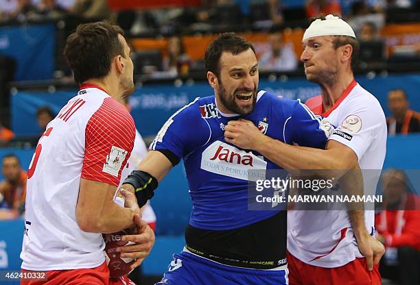 Croatia's Igor Vori tries to get past Polish defenses during the 24th Men's Handball World Championships quarterfinals match between Poland and...