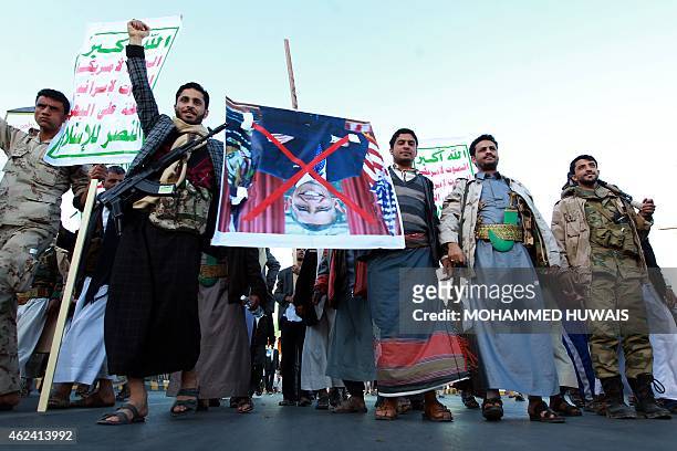 Yemeni Shiite supporters of the Huthi movement carry an upside down portrait of US President Barack Obama bearing a red cross over it, during a march...