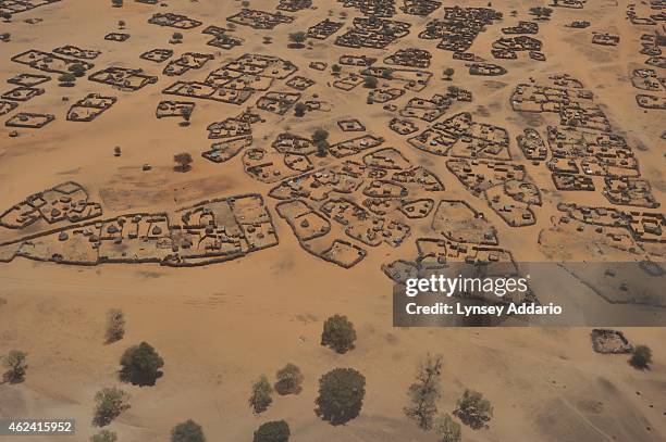 An old couple walks through the remains of a camp formally for internally displaced people from the Zaghawa tribe in Muhajariya, in South Darfur,...