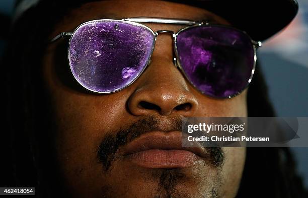 Running back Marshawn Lynch of the Seattle Seahawks sits at a podium during a Super Bowl XLIX media availability at the Arizona Grand Hotel on...