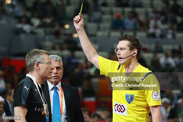 Referee Lars Geipel of Germany shows head coach Gudmundur Gudmundsson of Denmark the yellow card during the quarter final match between Spain and...