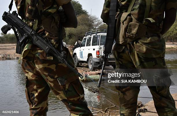 Picture taken on January 27, 2015 shows Chadian soldiers watching as a UN vehicle from a United Nations' refugee agency convoy crosses a branch of...