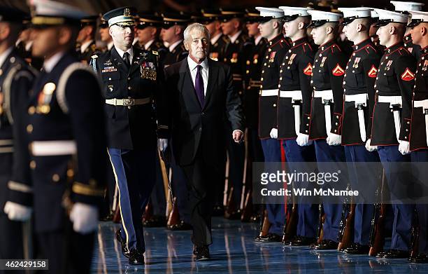 Secretary of Defense Chuck Hagel reviews troops with Old Guard Commander Army Col. Johnny Davis during a farewell ceremony for Hagel at Fort Myer...