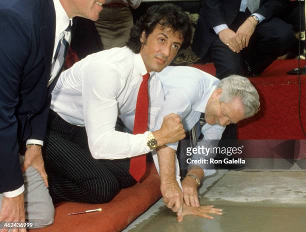 Actor Sylvester Stallone places his hand & footprints in cement on June 29, 1983 at the Mann's Chinese Theatre in Hollywood, California.