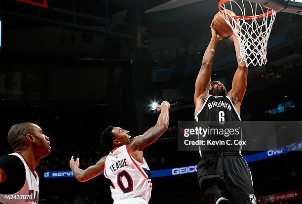 Alan Anderson of the Brooklyn Nets dunks against Jeff Teague and Al Horford of the Atlanta Hawks at Philips Arena on January 28, 2015 in Atlanta,...
