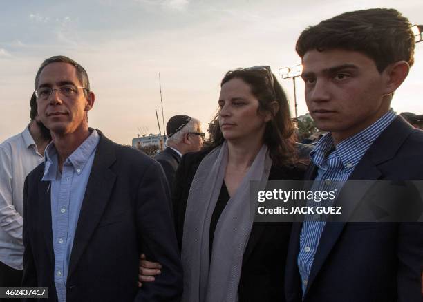 Gilad Sharon , the son of Israel's former prime minister Ariel Sharon, leaves the grave site with his wife Inbal and son, following Sharon's funeral...