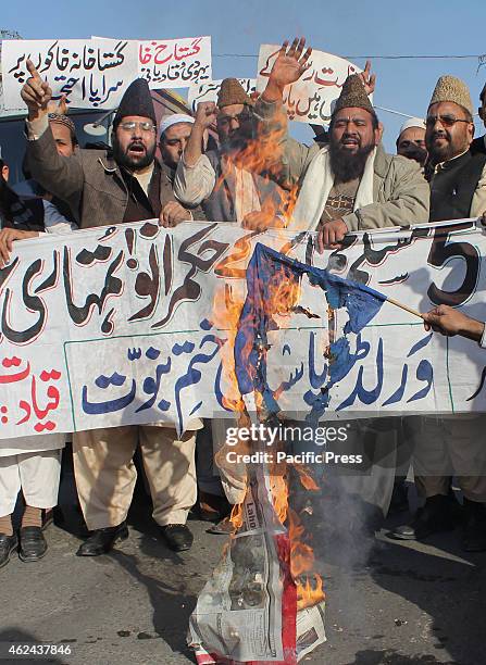 Pakistani religious activists from the World Pasban Khatam-e- Nabuat burning the flag of France during a protest against the printing of satirical...