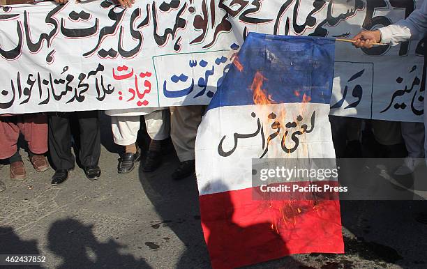 Pakistani religious activists from the World Pasban Khatam-e- Nabuat burning the flag of France during a protest against the printing of satirical...