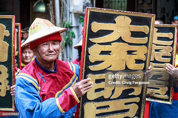 Temple sign bearer poses ahead of the annual birthday rituals of the Qingshan Wang deity or Lord of the Green Mountain.