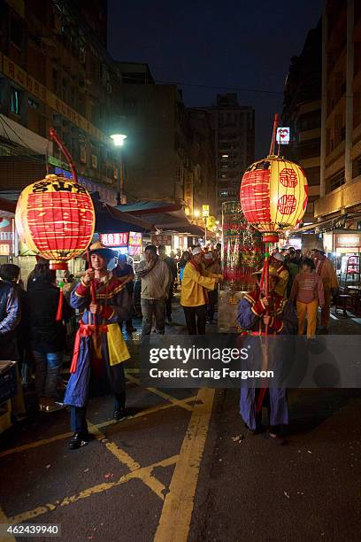 Lantern bearers lead the procession through a night market as the birthday festival for deity Qingshan Wang gets underway.