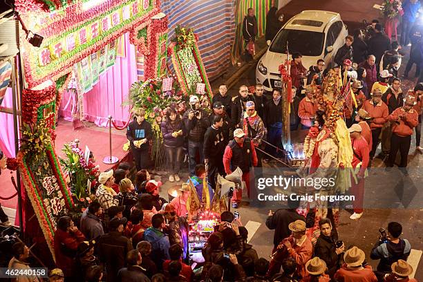 Crowds gather around a makeshift shrine at the side of the road during birthday rituals for the deity Qingshan Wang.