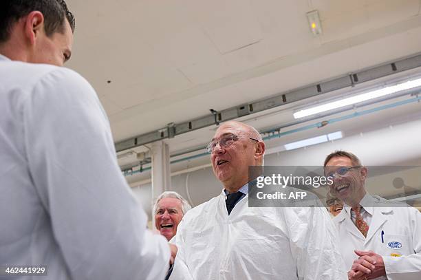 French Labour, Employment and Social Dialogue minister Michel Sapin shares a laught with employees as he visits the Magneti Marelli factory on...