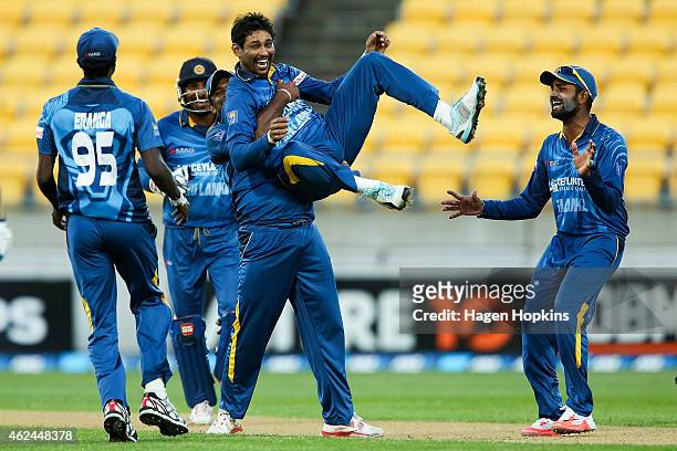 Tillakaratne Dilshan of Sri Lanka is congratulated by teammates Shaminda Eranga , Seekkuge Prasanna and Lahiru Thirimanne after taking the wicket of...