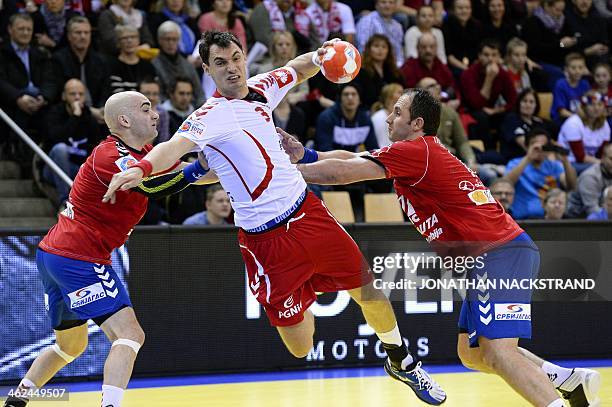 Serbia's pivot Alem Toskic and his teammate left back Momir Ilic try to stop Poland's right back Krzysztof as he jumps to score during the men's EHF...