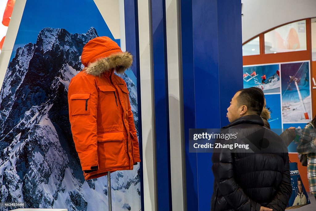 A man is studying carefully the exhibited outdoor snowsuit...