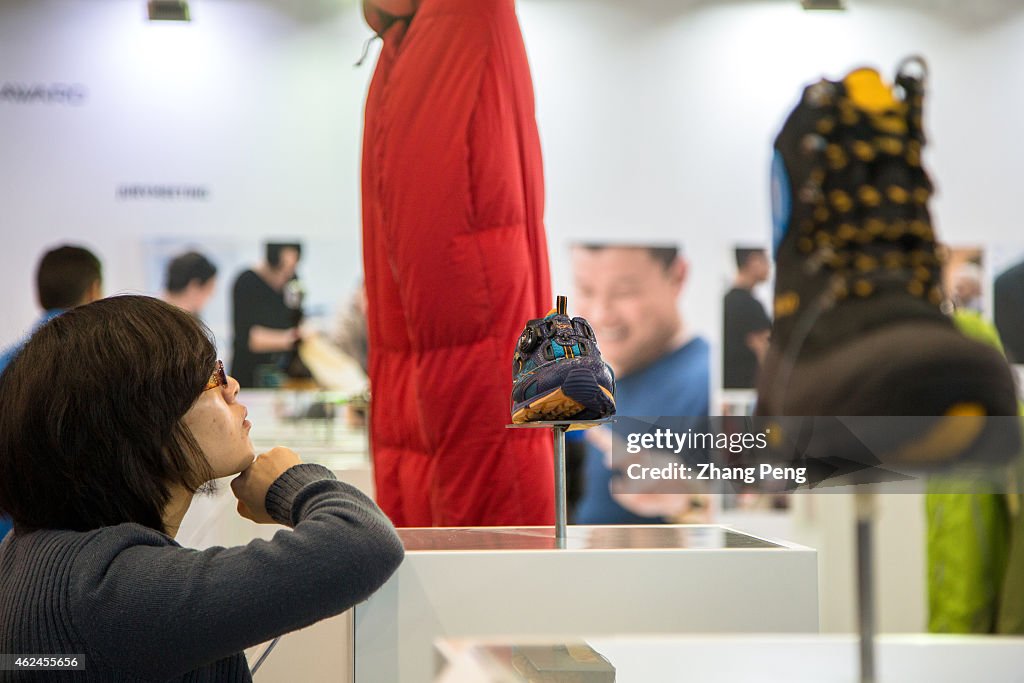 Visitors study carefully the exhibited outdoor goods on ISPO...