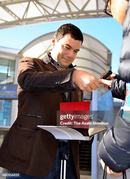 French economist Thomas Piketty signs autograph on arrival at Narita International Airport on January 29, 2015 in Tokyo, Japan.