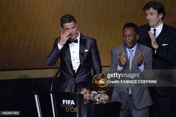 Brazilian football legend Pele applauds next to Real Madrid's Portuguese forward Cristiano Ronaldo as he cries after receiving the 2013 FIFA Ballon...