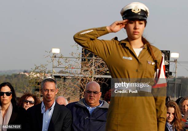 An Israeli soldier salutes in front of the sons of former Israeli Prime Minister Ariel Sharon, Gilad and Omri , during their father's funeral near...