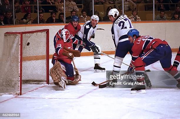 Darryl Sittler of the Toronto Maple Leafs puts one past Richard Sevigny of the Montreal Canadiens as Dan Maloney of the Leafs and Rod Langway and...
