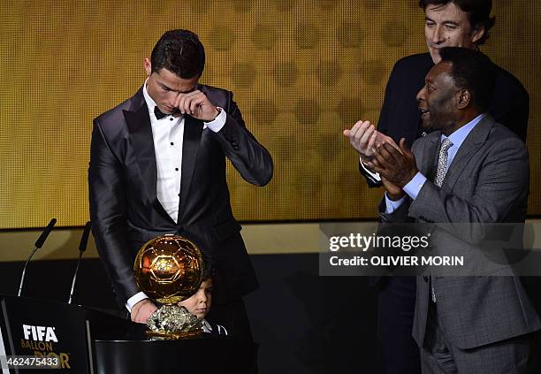 Real Madrid's Portuguese forward Cristiano Ronaldo cries after receiving the 2013 FIFA Ballon d'Or award for player of the year from Brazilian...