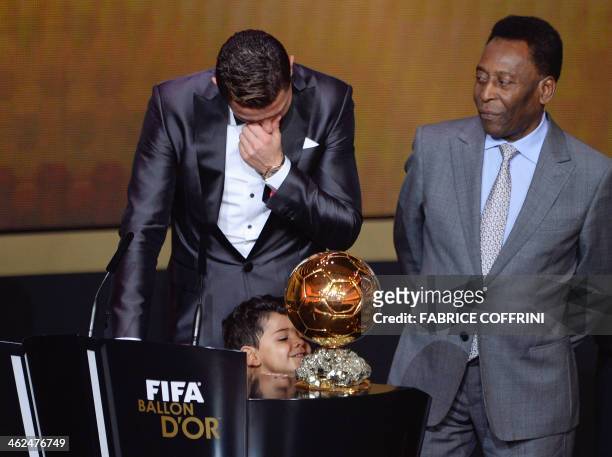 Real Madrid's Portuguese forward Cristiano Ronaldo cries next to his son Cristiano Ronaldo Junior and Brazilian football legend Pele after winning...