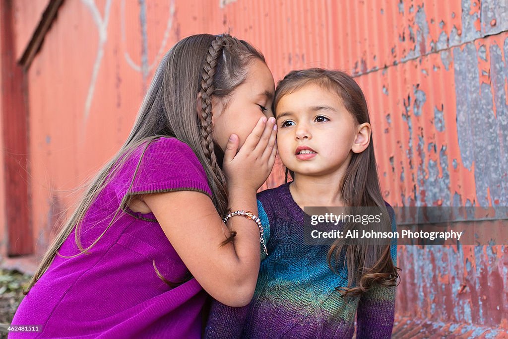 A girl tells her little sister a secret