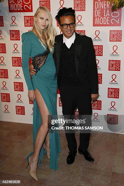 Model Yulia Lobova and businessman Omar Harfouch pose as they arrive to attend the 2015 Sidaction Gala Dinner, in Paris, on January 29, 2015. AFP...