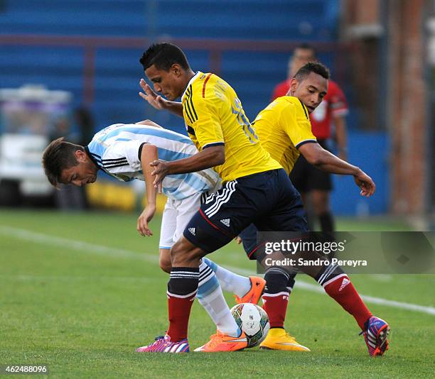 Nicolas Tripichio of Argentina and Bryan Rovira and Juan Barrera of Colombia fight for the ball during a match between Argentina and Colombia as part...