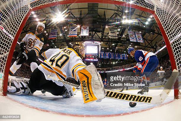 Zdeno Chara of the Boston Bruins looks on as Tuukka Rask of the Boston Bruins makes a stick save on a shot from Michael Grabner of the New York...