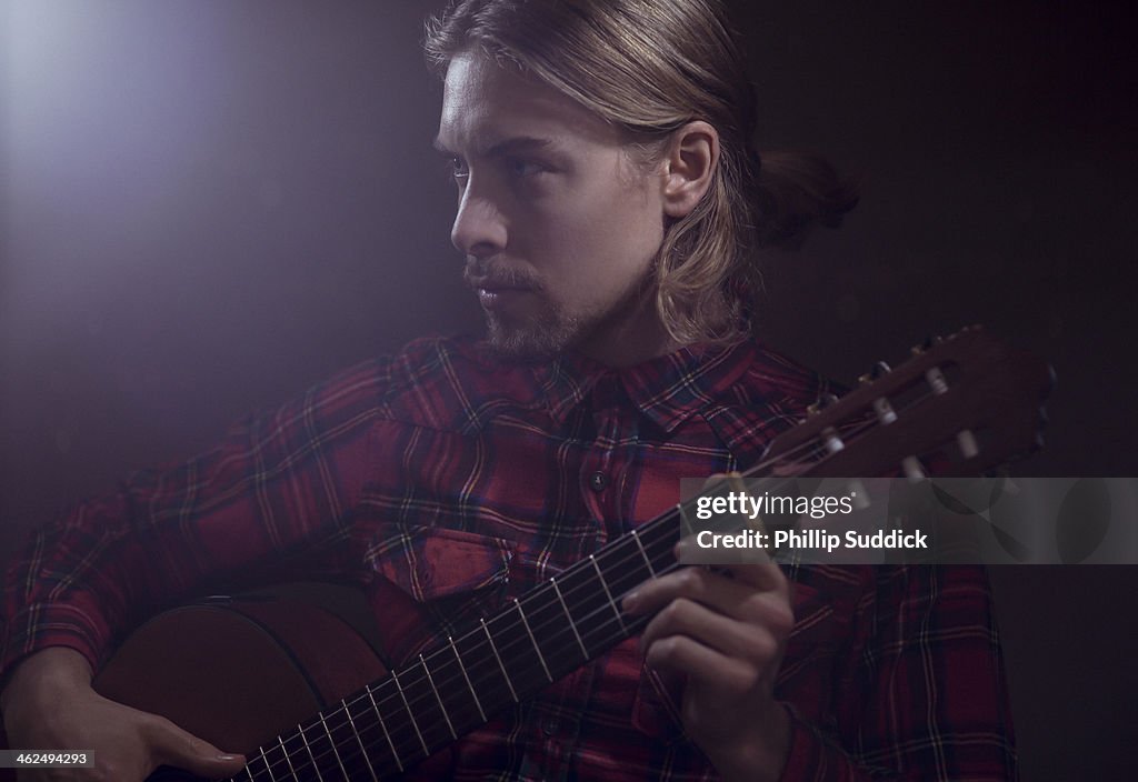 Long haired man with goatee playing guitar