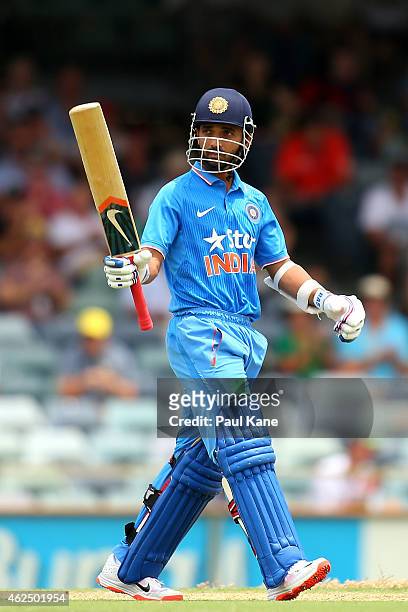 Ajinkya Rahane of India raises his bat to celebrate his half century during the One Day International match between England and India at the WACA on...