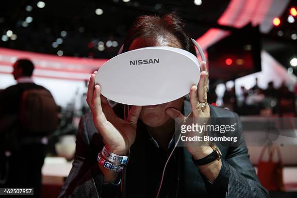 An attendee uses virtual reality goggles to view and create Nissan Motor Co. IDx concept vehicles during the 2014 North American International Auto...