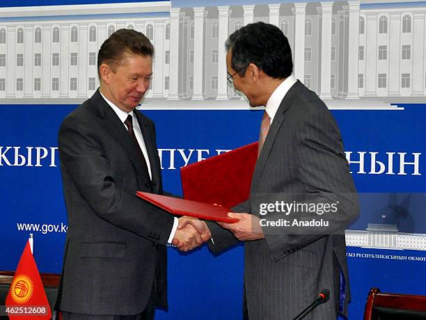 Chairman of the Board of Gazprom Alexey Miller and Djoomart Otorbaev shake hands after signing a protocol on cooperation in expanding the natural gas...