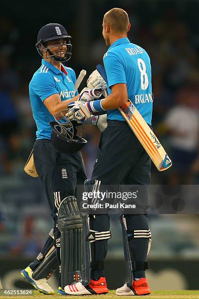 Chris Woakes and Stuart Broad of England celebrate after winning the One Day International match between England and India at WACA on January 30,...