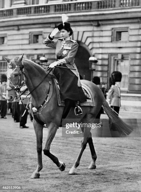 Britain's Queen Elizabeth II rides on June 7, 1952 a horse side saddle and salutes during a Trooping of the Colour ceremony at Horse Guard's Parade,...