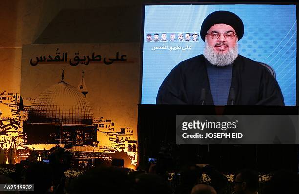Shiite supporters watch Hassan Nasrallah, the head of Lebanon's militant Shiite Muslim movement Hezbollah, addressing them through a giant screen on...