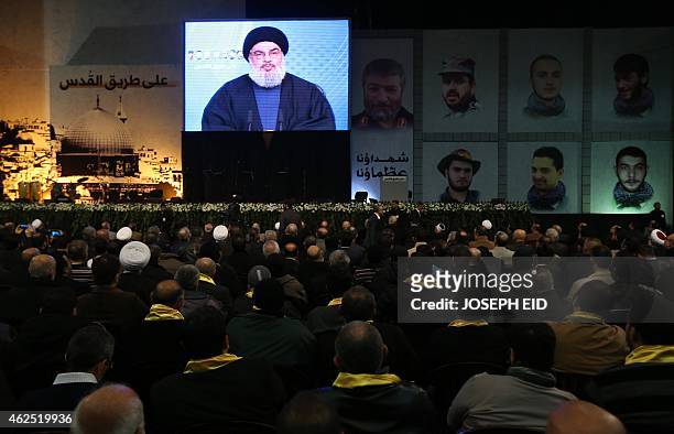 Shiite supporters watch Hassan Nasrallah, the head of Lebanon's militant Shiite Muslim movement Hezbollah, addressing them through a giant screen on...