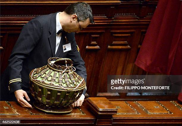 An employee of the parliament removes a ballot box after a vote at the Italian Parliament in Rome on January 30 on the second day of vote for the...