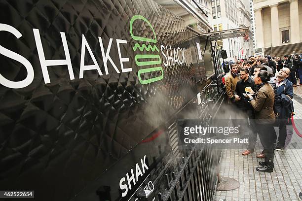 People line up for free Shake Shack hamburgers outside of the New York Stock Exchange during the burger company's IPO on January 30, 2015 in New York...