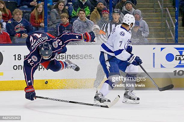 Radko Gudas of the Tampa Bay Lightning knocks Artem Ansimov of the Columbus Blue Jackets off his feet while chasing after the puck during the second...
