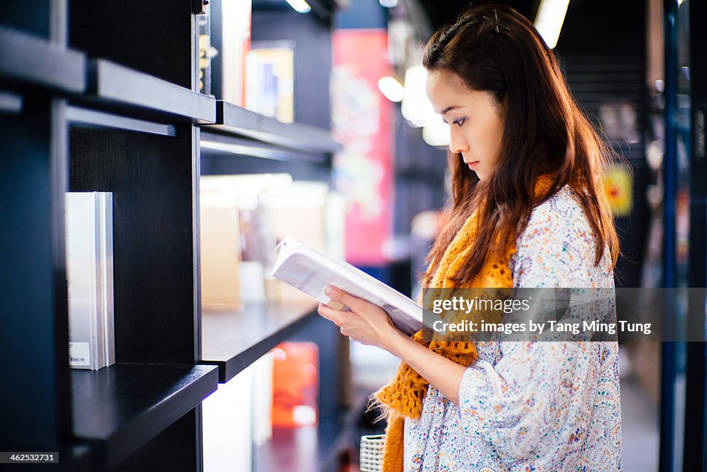 Young lady reading book in a bookstore