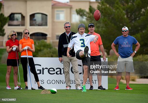Richard Lee punts a football during a kicking contest at the PGA TOUR Wives Association charity golf outing during the Waste Management Phoenix Open,...