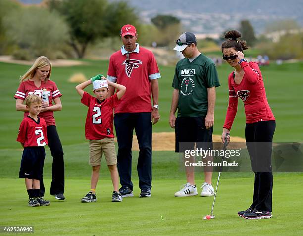 Sybi Kuchar studies her putt as her husband, Matt Kuchar watches at the PGA TOUR Wives Association charity golf outing during the Waste Management...