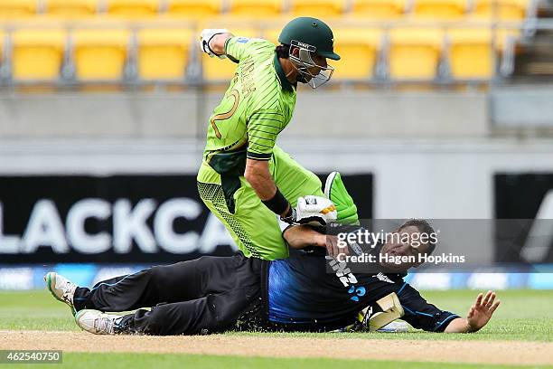 Nathan McCullum of New Zealand collides with Misbah-ul-Haq of Pakistan while attempting to field off his own bowling during the One Day International...