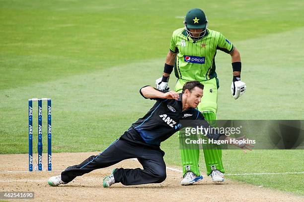 Nathan McCullum of New Zealand fields off his own bowling while Misbah-ul-Haq of Pakistan looks on during the One Day International match between New...