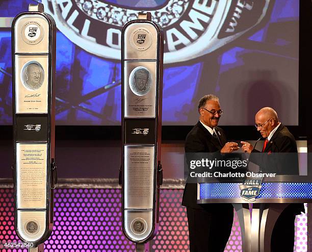 Former NASCAR driver Wendell Scott's son Franklin Scott hands his father's Hall of Fame ring to his brother, Wendell Scott Jr., right, during the...