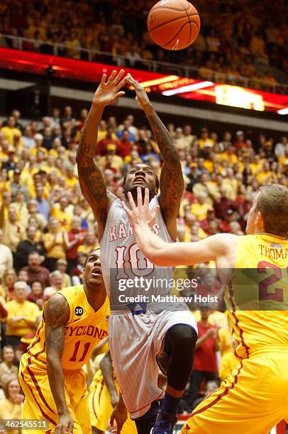 Guard Naadir Tharpe of the Kansas Jayhawks loses the ball during the first half driving against guard Matt Thomas of the Iowa State Cyclones on...