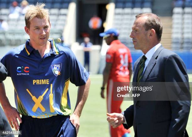 Australian Prime Minister Tony Abbott tosses the coin in front of Australian captain Brett Lee before his match against England at the Manuka Oval...